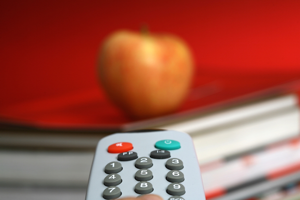 Foto che mostra un telecomando TV e una mela