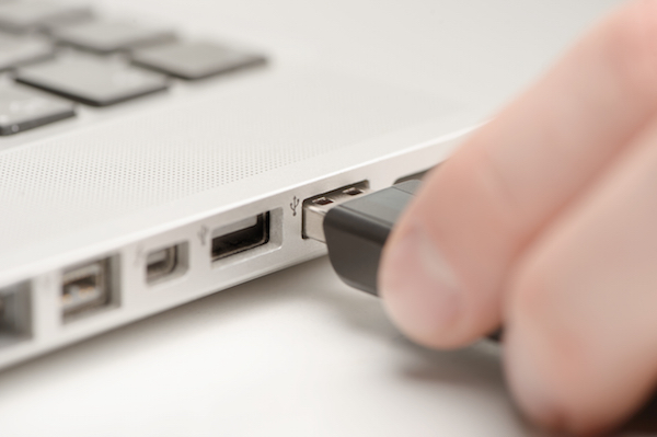 Immagine di una pendrive che viene inserita nella porta USB di un laptop
