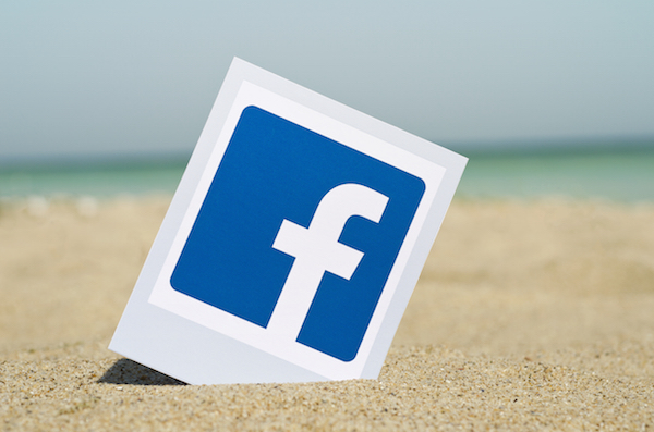 Foot che mostra il logo di Facebook sulla sabbia